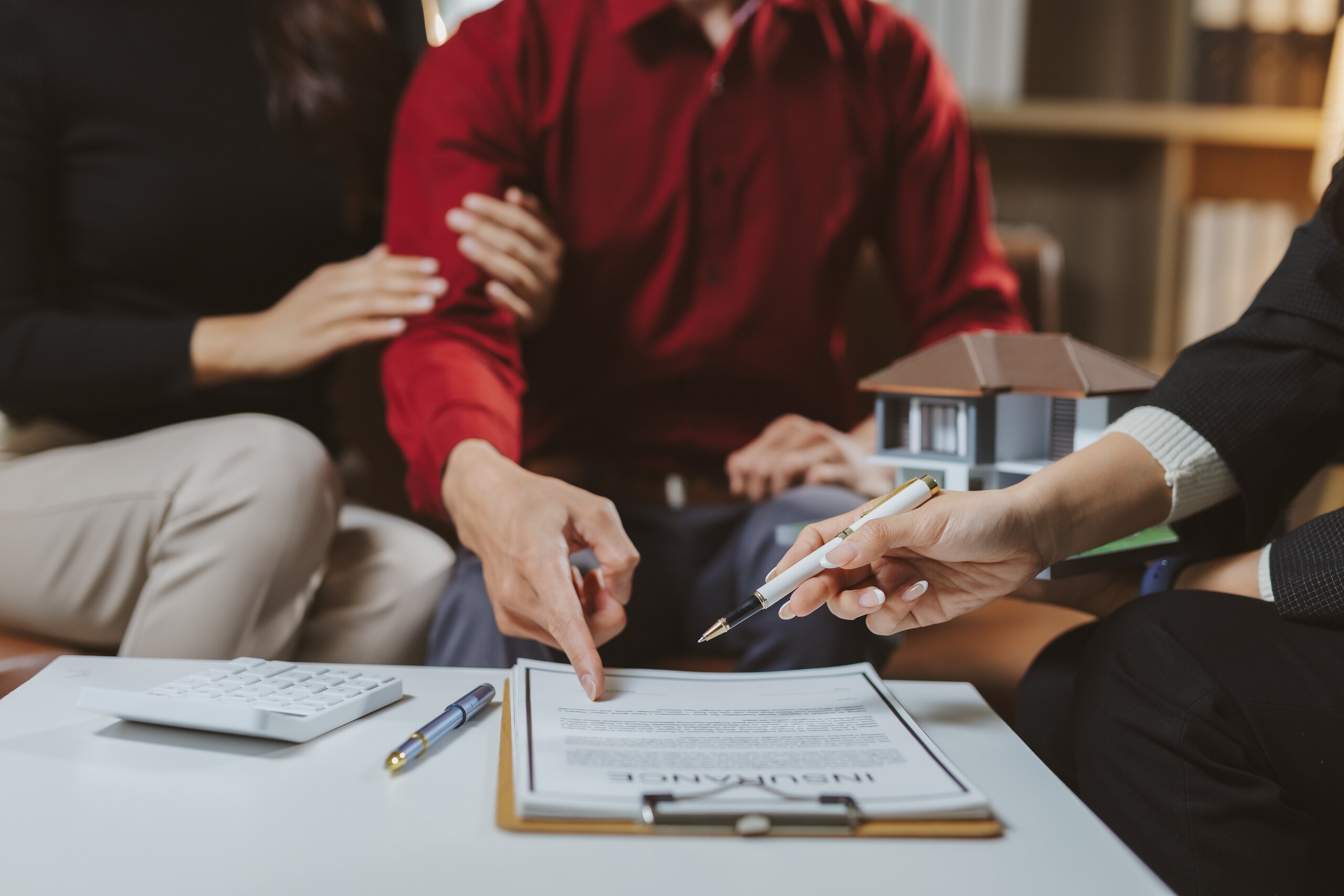 Florida homebuyers reviewing a real estate contract and earnest money deposit terms with a professional during a property purchase meeting