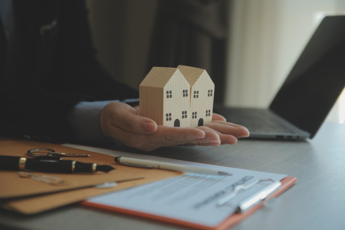 Marketable vs. insurable title concept shown with wooden house models and real estate documents at a Florida closing