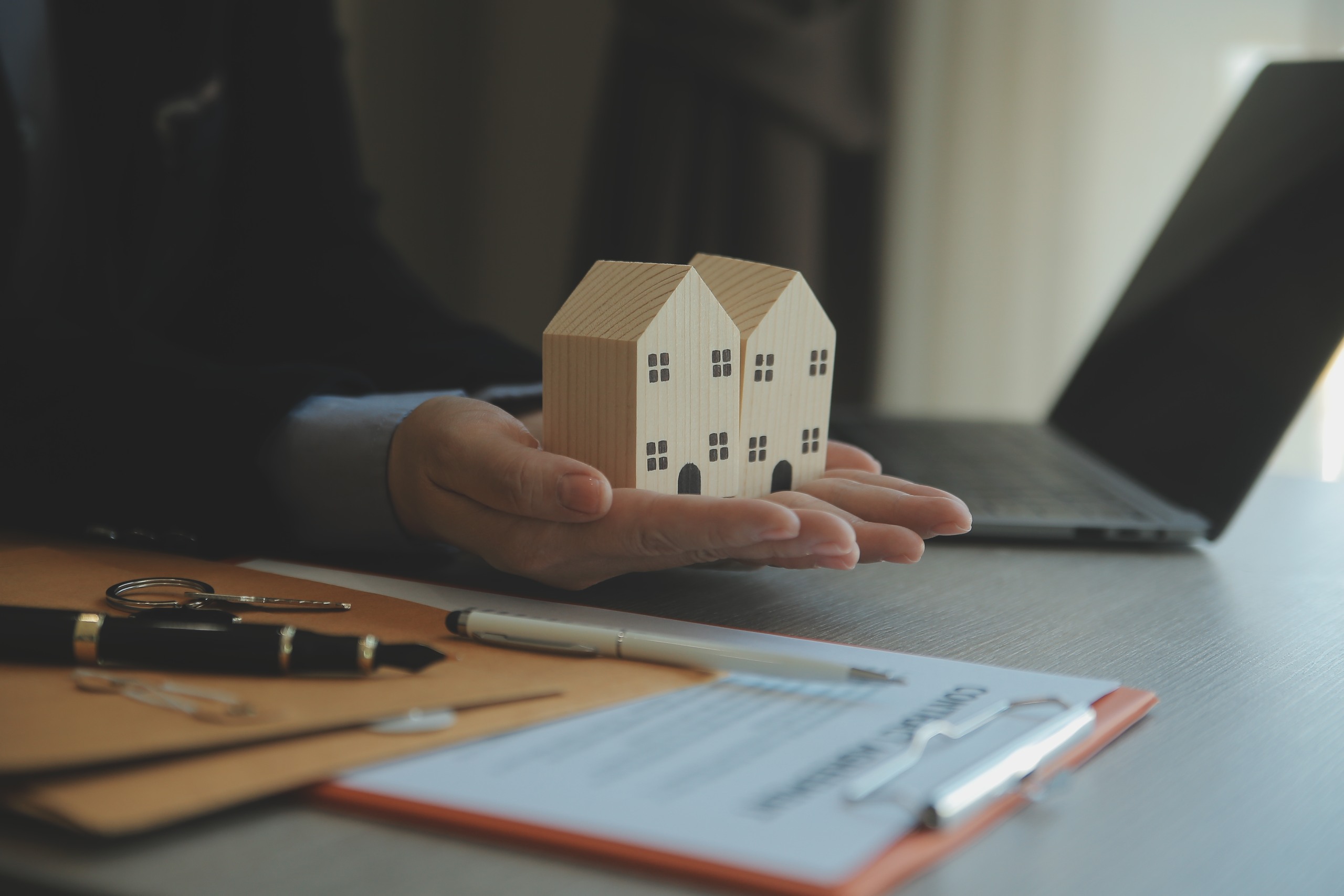 Marketable vs. insurable title concept shown with wooden house models and real estate documents at a Florida closing